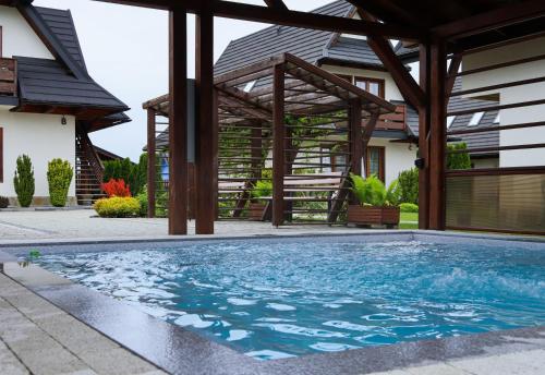 a swimming pool in the backyard of a house at PRZY TERMACH apartamenty, pokoje - podgrzewany basen, hydromasaż i tylko 70m Termy in Szaflary