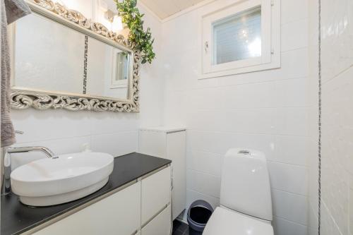 a white bathroom with a sink and a mirror at Pyynpesä ! in Rovaniemi