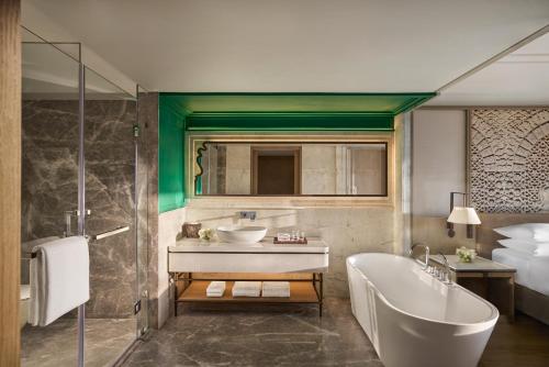 a bathroom with a tub and a sink and a bath tub at Udaipur Marriott Hotel in Udaipur