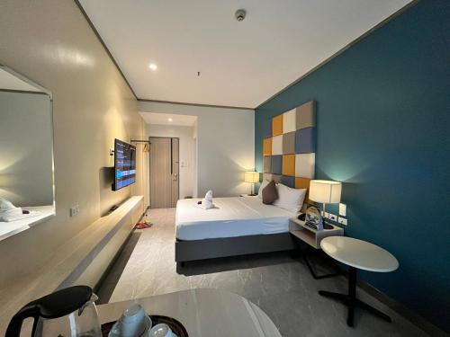 ein Schlafzimmer mit einem großen Bett und einer blauen Wand in der Unterkunft Yes Hotel Pandi Bulacan in Pandi