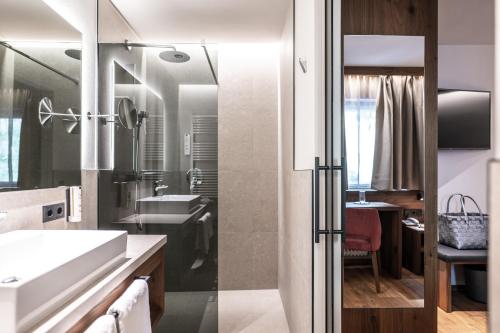 ein Badezimmer mit Dusche und Waschbecken in der Unterkunft Hotel Schmung in Alpe di Siusi