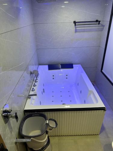 a bathroom with a tub with a toilet in it at Hotel Royal Empire in Gandhinagar