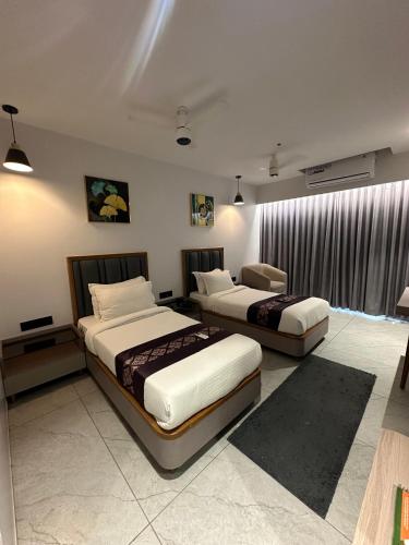 a bedroom with two beds and a window at Hotel Royal Empire in Gandhinagar