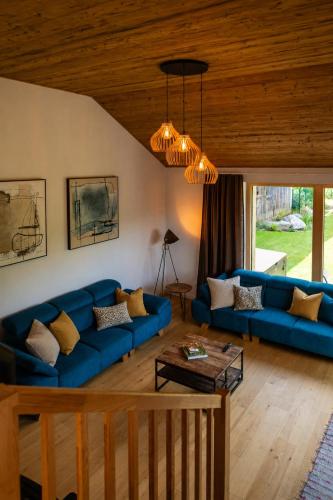 a living room with blue couches and a wooden ceiling at Villa ZENORIA in Zuberec