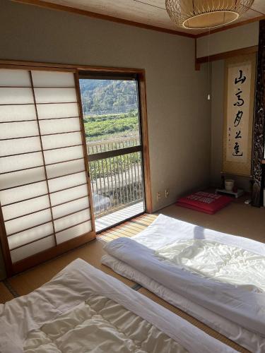 a bedroom with two beds and a large window at 鹿野寒舍館 in Tottori