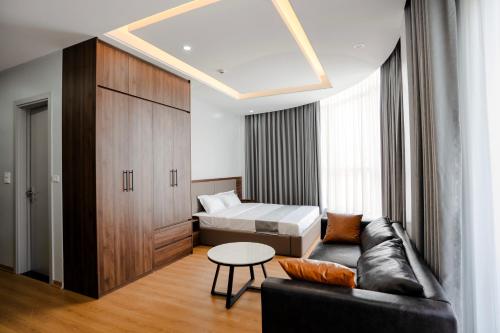 a room with a couch and a bed and a table at Lumia Hotel Vinh Yen in Vĩnh Phúc