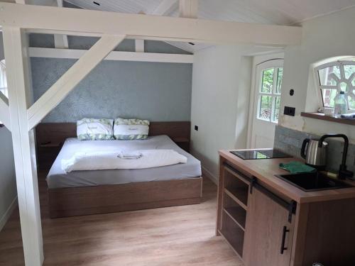 a bedroom with a bed and a sink in it at de Zeilende kraay in Katwijk