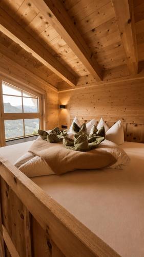 a bed in a log cabin with a window at Wieslhütte in Gerlosberg