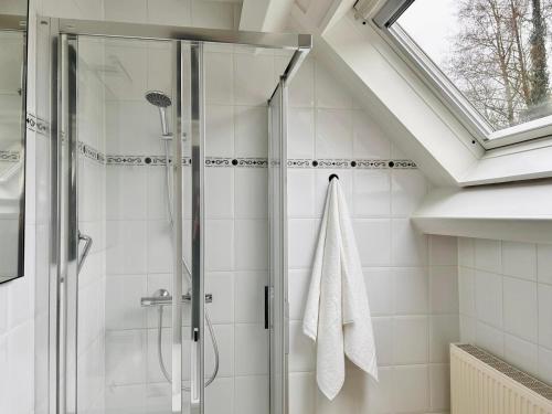 a bathroom with a shower with a glass door at Landgoed De Hoogmolen in Opglabbeek