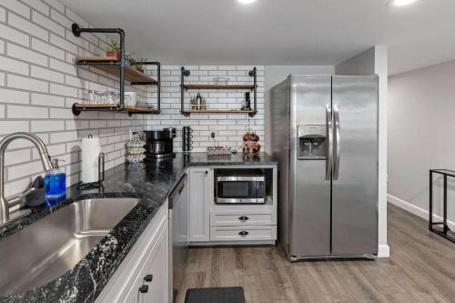 a kitchen with a stainless steel refrigerator and a sink at Industrial-Chic Loft-King Bed & Natural Light in Wheat Ridge