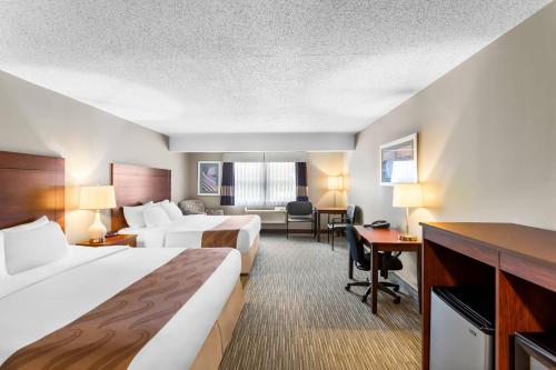 a hotel room with two beds and a desk at Quality Inn & Suites Gorham White Mountains in Gorham