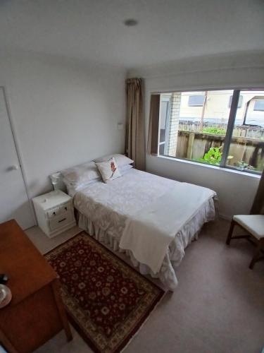 a small bedroom with a bed and a window at Modern Home in Central Location in New Plymouth