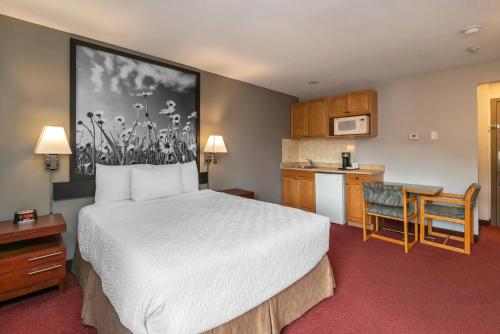 a hotel room with a bed and a kitchen at Quality Inn & Suites in Vernon