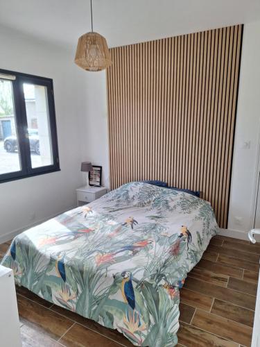 a bed with a colorful comforter in a bedroom at Appartement Indépendant à Terrerort in Saumur