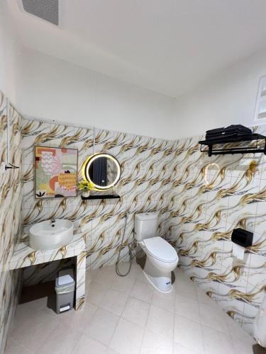 a bathroom with a toilet and a sink and a mirror at Nualam Glamping in Pasirangin
