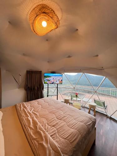 a bedroom with a bed and a large window at Nualam Glamping in Pasirangin