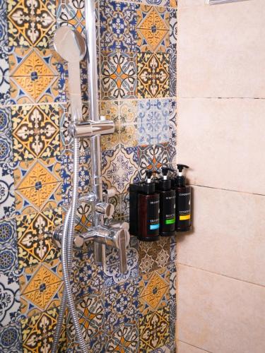 a shower in a bathroom with a tile wall at ECO ART Hotel in Tashkent