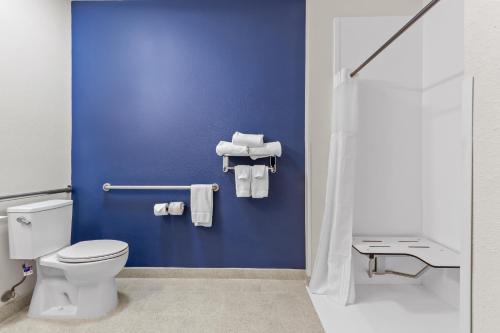 a bathroom with blue walls and a toilet and towels at Spark by Hilton Terrell in Terrell