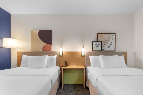a hotel room with two beds and a table at Spark by Hilton Terrell in Terrell