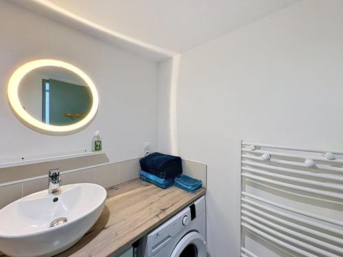 ein Badezimmer mit Waschbecken und Waschmaschine in der Unterkunft Le Peage de Perouges in Pérouges