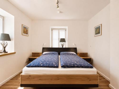a bedroom with a large bed with blue sheets at Guade Stub'n Franzi in Huglfing