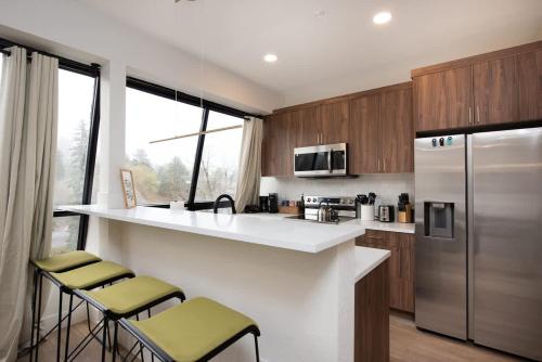 a kitchen with a counter and a refrigerator at Modern condo with town and mountain views in Evergreen