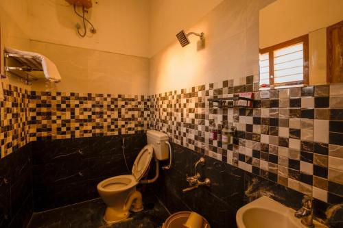 a bathroom with a toilet and a tub and a sink at Golden Loom Homestay in Kanchipuram