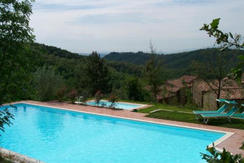 基安蒂蓋奧勒的住宿－Antico Borgo Montefienali Apartment Il Portico，一座大游泳池,后面是群山