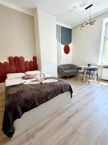 a bedroom with a large bed with a red headboard at Apartments Piotrkowska 67 in Łódź