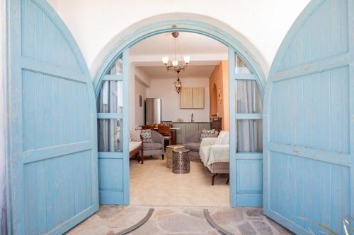 an archway in a living room with a blue door at Alma Libre Villas in Kastraki
