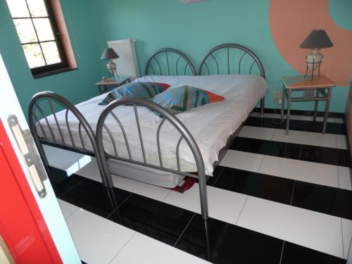 a bed in a room with a black and white floor at Guest house Western-city in Chaudfontaine