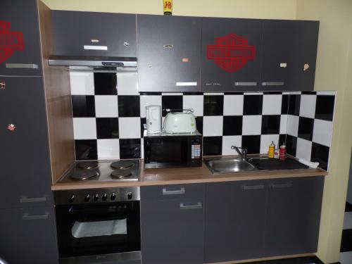 a small kitchen with black and white checkered wall at Guest house Western-city in Chaudfontaine