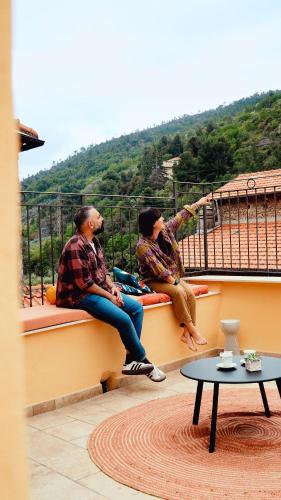 two men sitting on the ledge of a building at La Terrazza di Maddalena in Cisano sul Neva