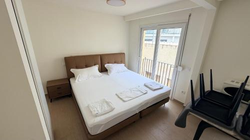 a bedroom with a bed and a chair and a window at Apartamentos Lin in Lloret de Mar