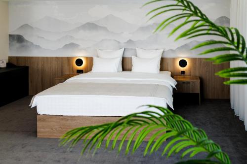 a bedroom with a bed with a mountain mural on the wall at Altay Resort in Shchūchīnsk