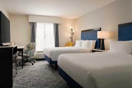 a hotel room with two beds and a desk at Hampton Inn Thomson in Thomson