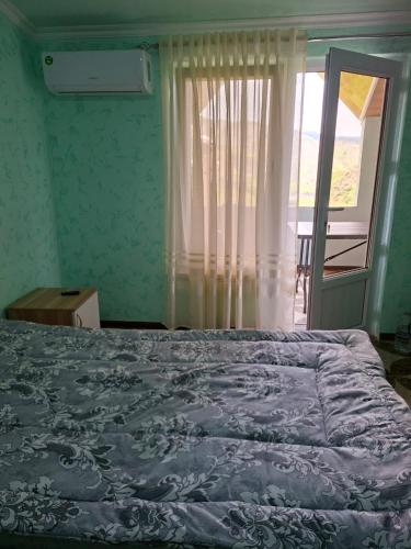 a bedroom with a large bed with a window and a window at Адами драхт in Garni
