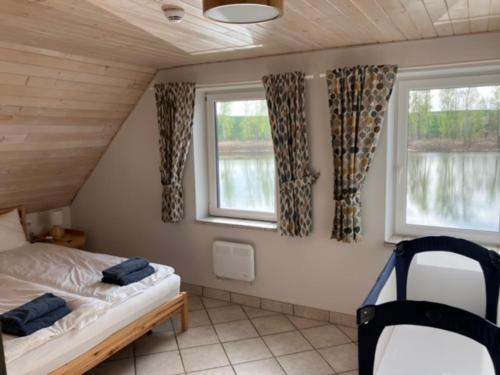 a bedroom with a bed and two windows at Dom Nowe Krzywe in Nowe Krzywe