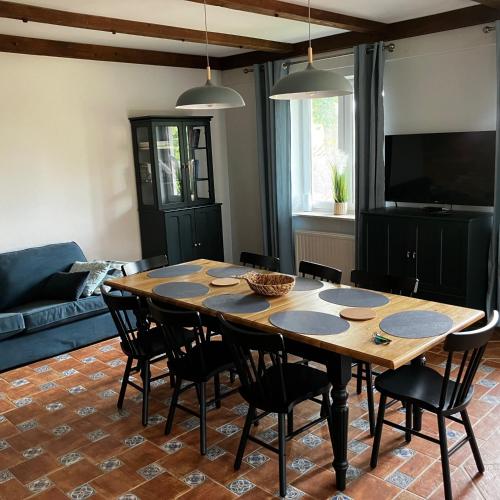 a living room with a wooden table and chairs at Dom Nowe Krzywe in Nowe Krzywe