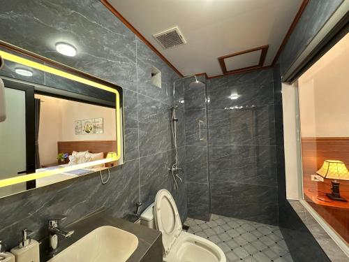 a bathroom with a shower and a toilet and a sink at TamCoc Golden Mountain Homestay in Vũ Lâm
