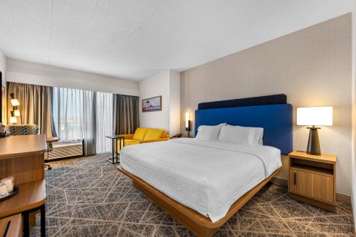 a hotel room with a large bed and a yellow chair at Hampton Inn Chicago-Gurnee in Gurnee