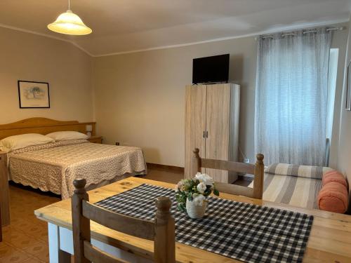 a bedroom with a bed and a table and a tv at Agriturismo Ca' Castellani in Bardolino