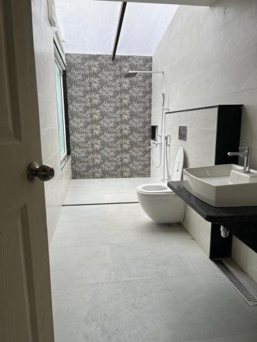 a bathroom with a toilet and a sink and a shower at Nature's Abode in Pune