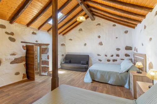 a bedroom with a bed and a couch in a room at Palmeral de Taidía in Taidía