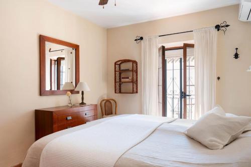 a bedroom with a large white bed and a window at Casa Pueblo Lopez in Fuengirola