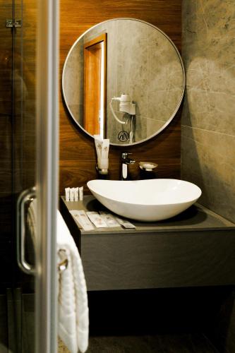 a bathroom with a white sink and a mirror at Altay Resort in Shchūchīnsk