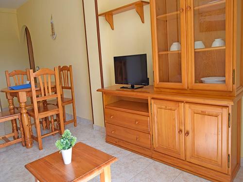 a living room with a television on a wooden cabinet at Apartamentos Costa Azahar 3000 in Alcossebre