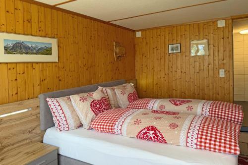 a bed with red and white pillows in a room at Studio bim Chalet bim Chilchli in Mürren