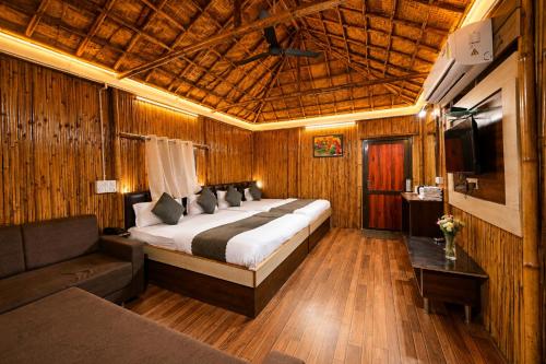 a bedroom with a large bed and a couch at Hotel Happy Forest -Boutique Garden Retreat in Mount Abu in Mount Ābu