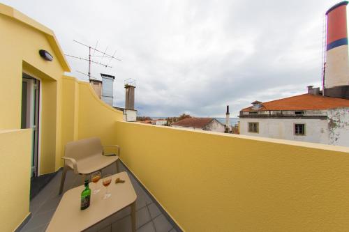 a yellow balcony with a chair and a table at The Marketplace by Storytellers in Funchal